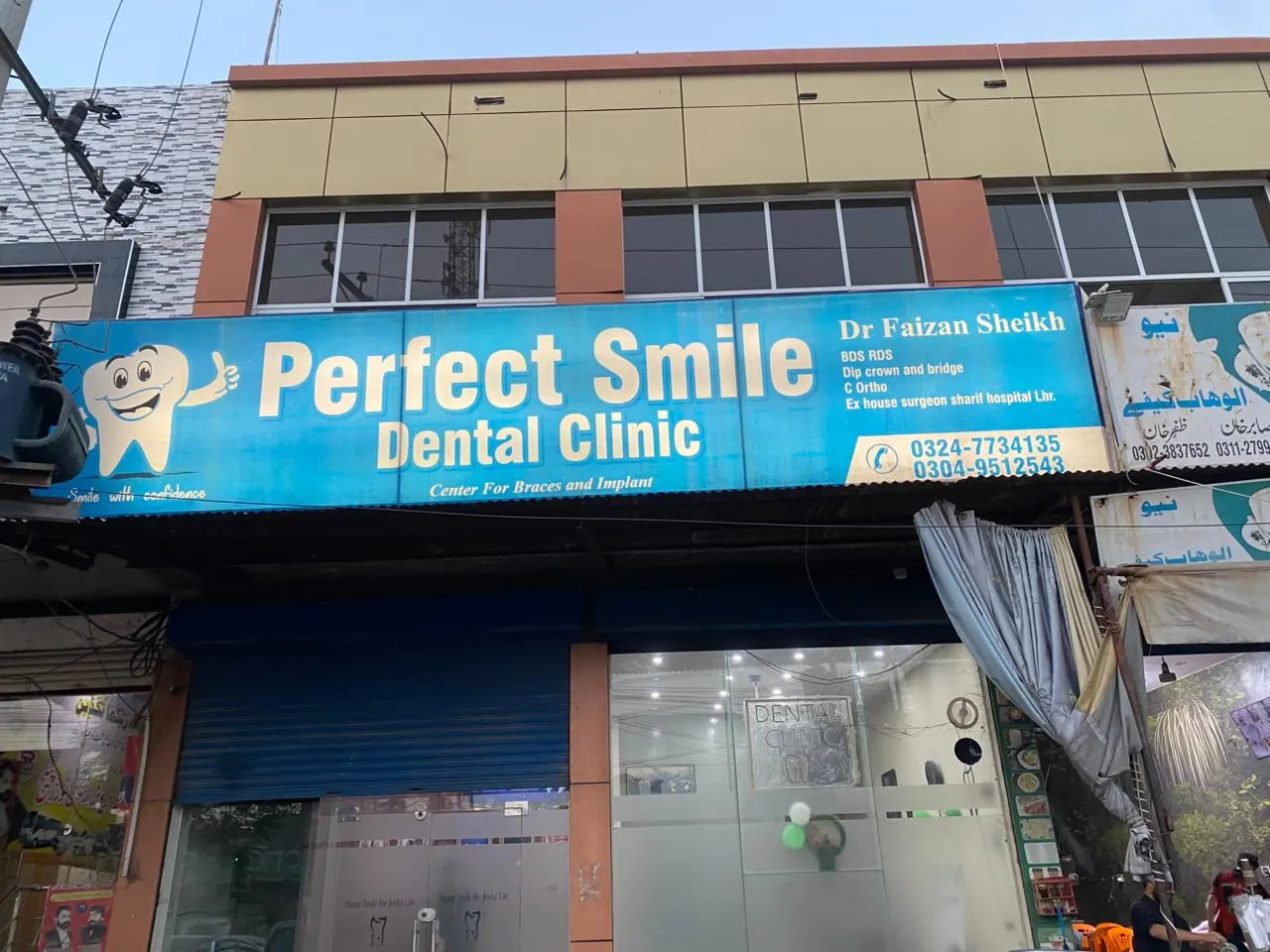 The Perfect Smile Dental Clinic signboard on Stayana Road, Faisalabad — Dr Faizan Sheikh, centre for braces and implants